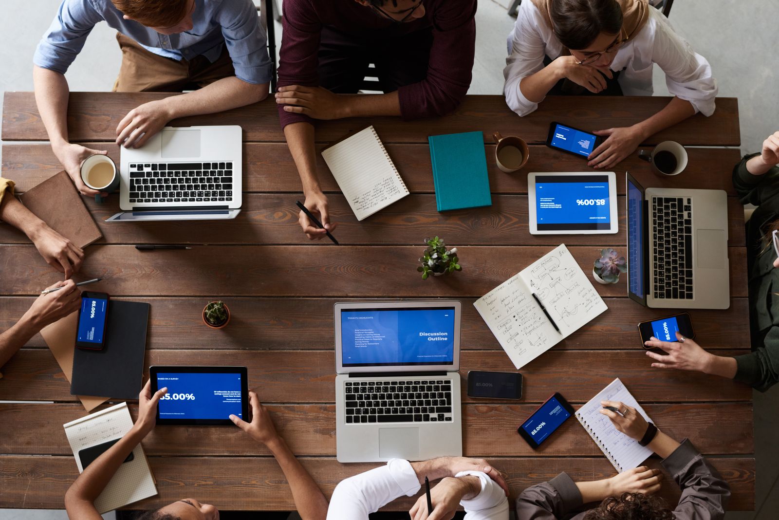 A multi-ethnic team collaborating around a table in a modern office, representative of a build-then-handover team
